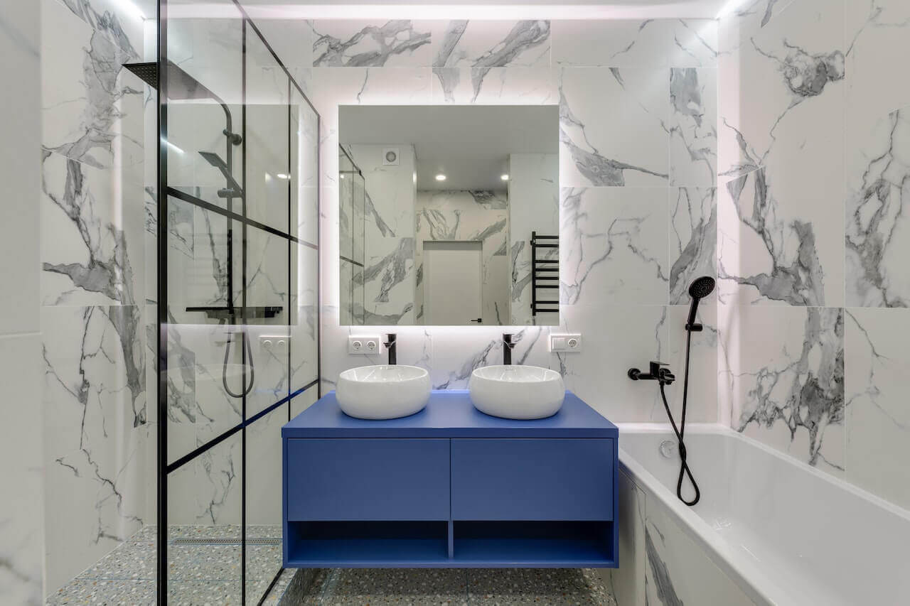 Badrum med stark blå-lila färg på en badrumsmöbel.
